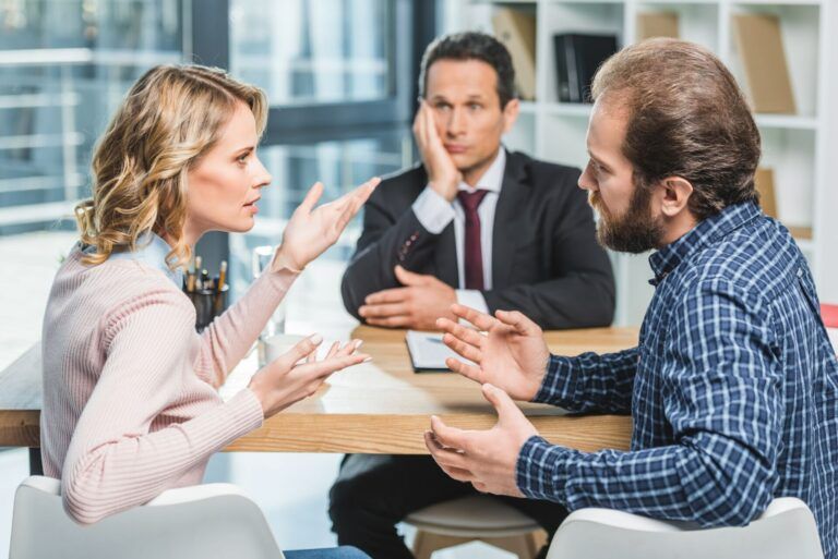 side view of couple arguing at workplace in lawyer office