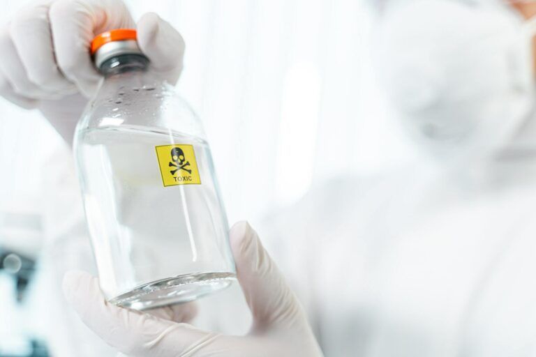 Competent researcher holding bottle with dangerous liquid